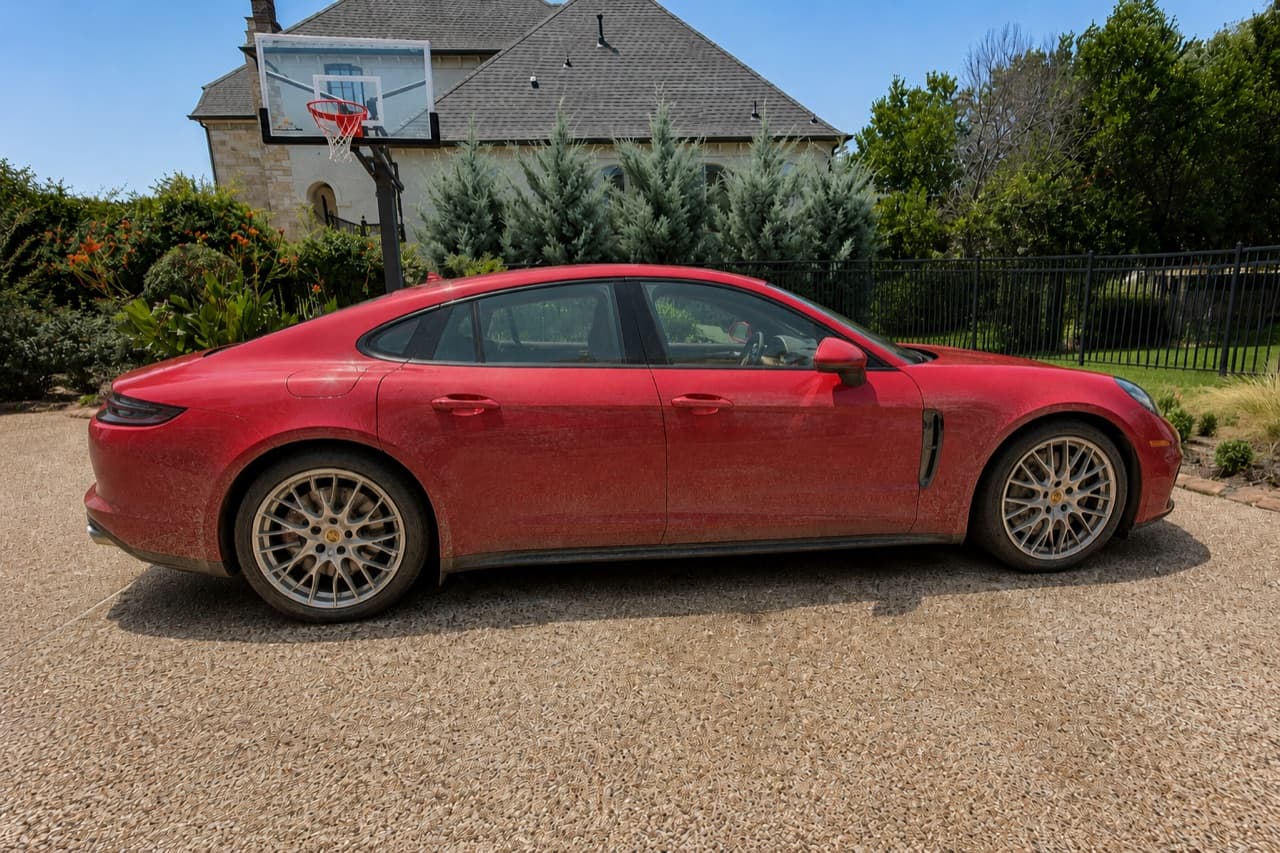 Red Porsche Panamera exterior, dusty before and gleaming after a detail — before